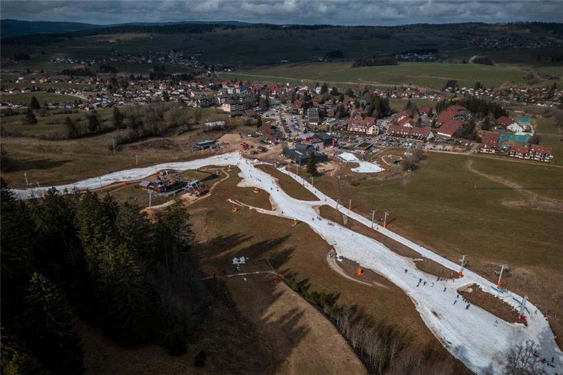Skipisten in einer schneefreien Landschaft im französischen Jura-Skigebiet Métabief
