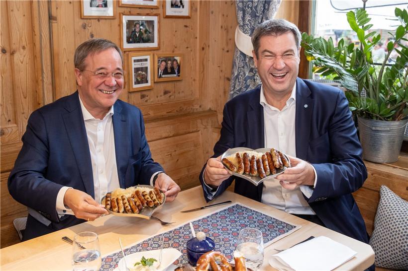 Sollte dies ein Beitrag dazu sein, dem Wahlkampf zu mehr Ernsthaftigkeit zu verhelfen? Markus Söder (r.) und Armin Laschet essen zusammen in einem Bratwurst-Restaurant Nürnberger Würstchen
