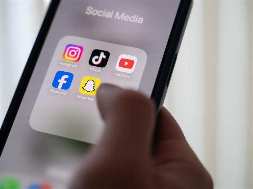 Menschen nutzen soziale Medien, während im Hintergrund Symbole für rauen Umgangston und Online-Kommentare sichtbar sind