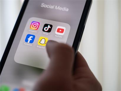 Menschen nutzen soziale Medien, während im Hintergrund Symbole für rauen Umgangston und Online-Kommentare sichtbar sind
