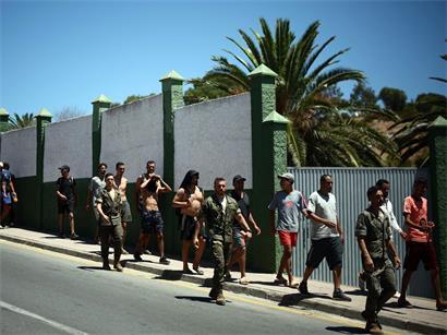 Spanische Soldaten begleiten eine Gruppe irregulärer Migranten in Ceuta an die Grenze zu Marokko