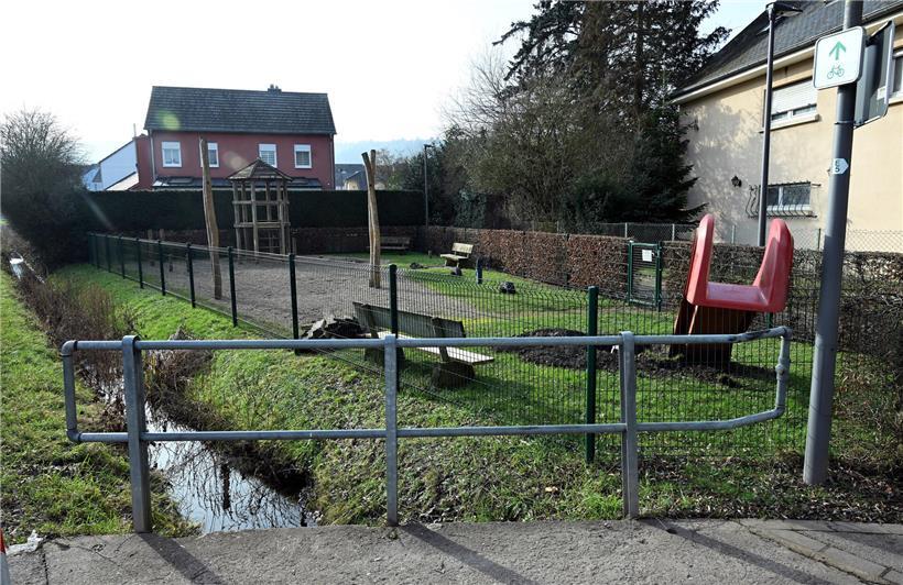 Baumsetzlinge auf einem Spielplatz, der künftig anstelle einer Rutsche begrünt wird, nachhaltige Stadtplanung sichtbar