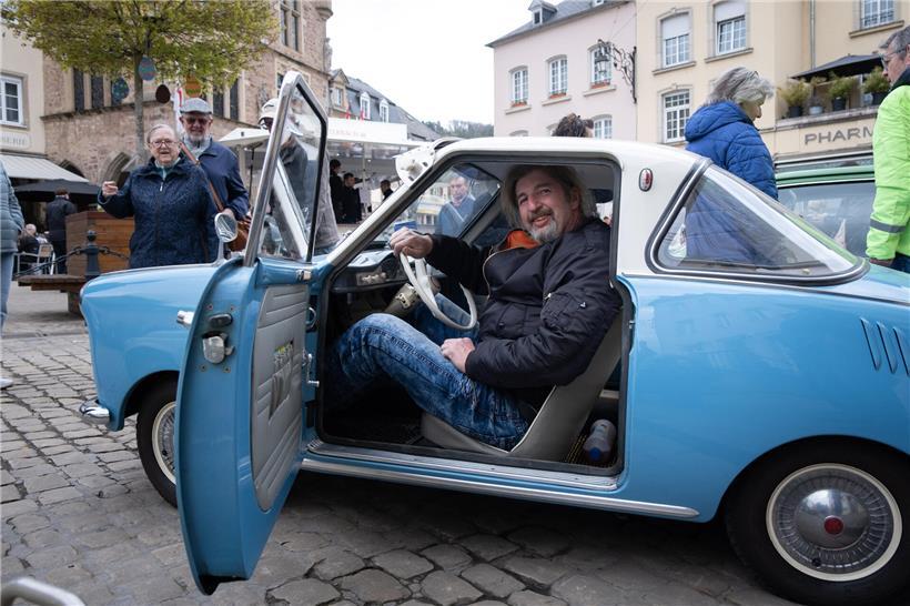 Stefan Grün sitzt in seinem klassischen Goggomobil Coupé 250 von 1965, Oldtimer in leuchtendem Blau
