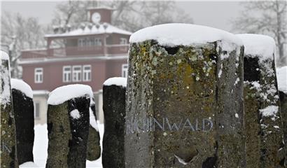 Steine mit den Namen von Konzentrationslagern, darunter Buchenwald, stehen in der Gedenkstätte Buchenwald im Schnee.
