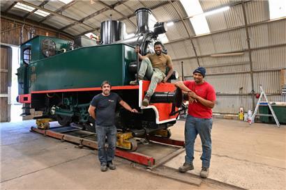 Stolz auf die geleistete Arbeit (v.l.n.r.): Filipe Da Cruz Nascimento, Adelio Gomes Moreira und Willian Lopes Monteiro vor der Hanomag. Nach gut einem Jahr Restaurierung wird die Dampflokomotive am 10. September wieder an ihren ursprünglichen Standort am „Schlassgoart“ zurückkehren. 
