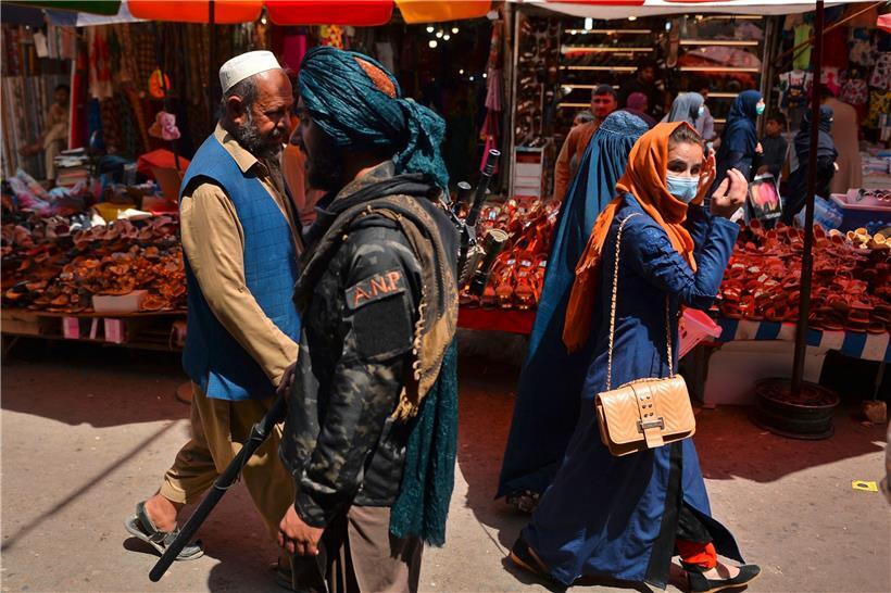 Straßenszene in Kabul: Ein Taliban-Kämpfer geht über einen Straßenmarkt
