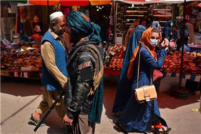 Straßenszene in Kabul: Ein Taliban-Kämpfer geht über einen Straßenmarkt
