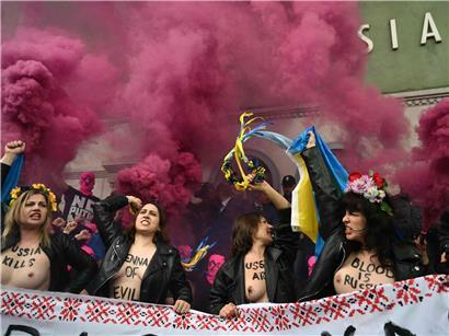 Aktivistinnen von Pussy Riot und Femen mit Sturmhauben und Blumenkränzen vor dem russischen Pavillon