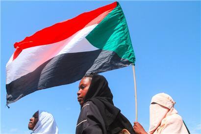 Sudanesische Schüler halten während einer Protestkundgebung gegen die Verstöße der Rapid Support Forces (RSF) gegen die Bevölkerung die sudanesische Flagge hoch
