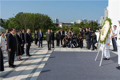 Südkoreas Präsident Yoon Suk-yeol, Ehefrau Kim Keon-hee und Luxemburgs Premierminister Xavier Bettel (v.l.n.r.) an der Gedenkmauer des UN-Friedhofs

