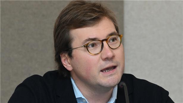 Porträt von Sven Schaul, lächelnder Mann mit Brille vor neutralem Hintergrund, Business-Foto