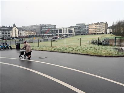 Rentnerin läuft an leerstehendem Baugrundstück in Luxemburg-Stadt – Symbolbild für Wohnungs- und Rentenkrise