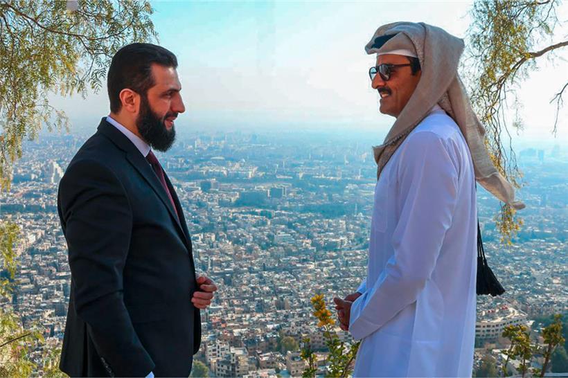 Syriens Übergangspräsident Ahmed al-Scharaa im Gespräch mit dem Emir von Katar, Tamim bin Hamad al-Thani, mit Damaskus im Hintergrund
