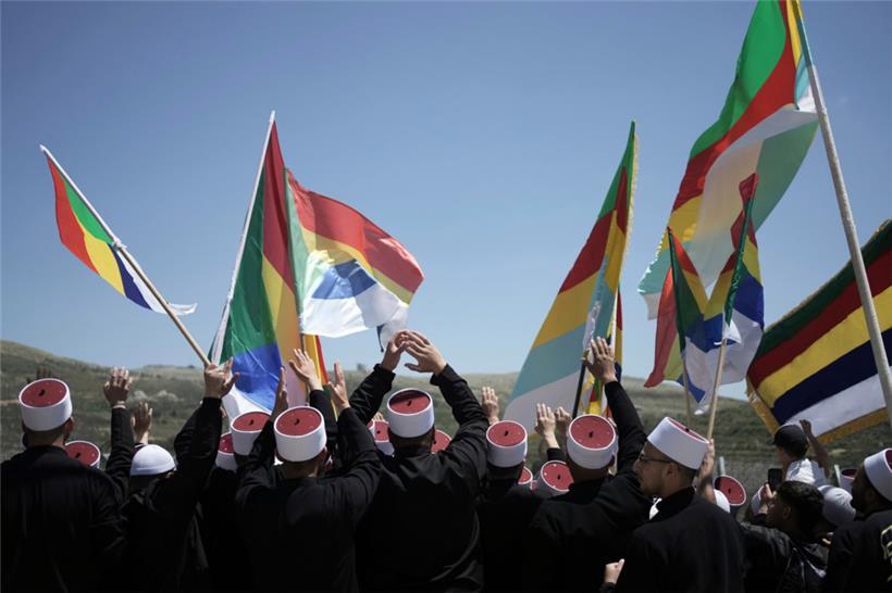 Syrische drusische Geistliche werden von Mitgliedern der israelischen drusischen Gemeinschaft an der Grenze zu Syrien begrüßt, als sie in die Stadt Majdal Shams auf den israelisch kontrollierten Golanhöhen einreisen, um den Schrein des Propheten Nabi Shuaib zu besuchen
