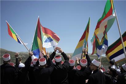 Syrische drusische Geistliche werden von Mitgliedern der israelischen drusischen Gemeinschaft an der Grenze zu Syrien begrüßt, als sie in die Stadt Majdal Shams auf den israelisch kontrollierten Golanhöhen einreisen, um den Schrein des Propheten Nabi Shuaib zu besuchen
