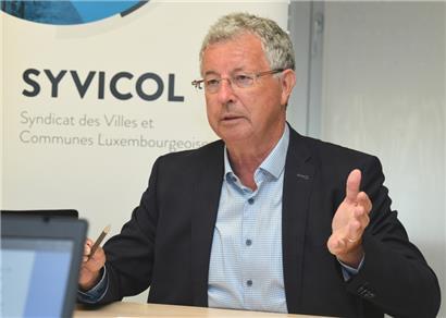 Syvicol-Präsident Emile Eicher: „Wir bedauern, dass sich die Unterstützung des Staates beim Bauen von erschwinglichem Wohnraum nicht auf reelle Kosten bezieht, sondern auf Höchstbeträge, die seit Jahren gedeckelt sind, also nicht mit den erheblichen Preissteigerungen im Bausektor schritthalten.“

