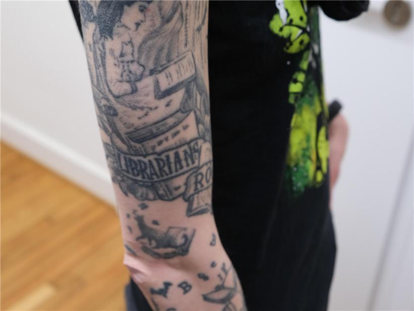 Getarnte Tiere und die Hüterin von 60.000 Schätzen Frau Tami mit Tattoo, das ihre Leidenschaft für ihren Beruf symbolisiert, glückliches Porträt im Büro