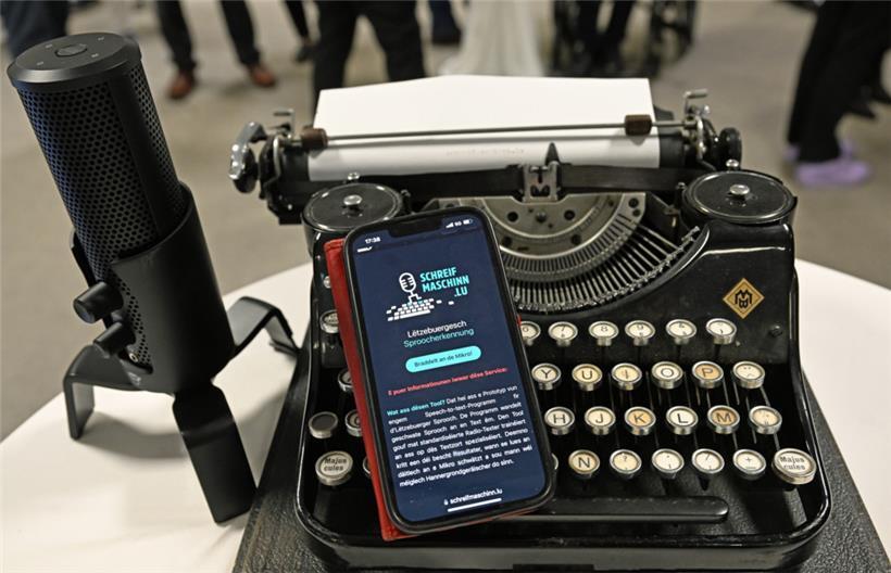 Technische Quantensprünge: Ein Smartphone, das auf einer alten Schreibmaschine liegt, zeigt das neue Programm für luxemburgische Spracherkennung an
