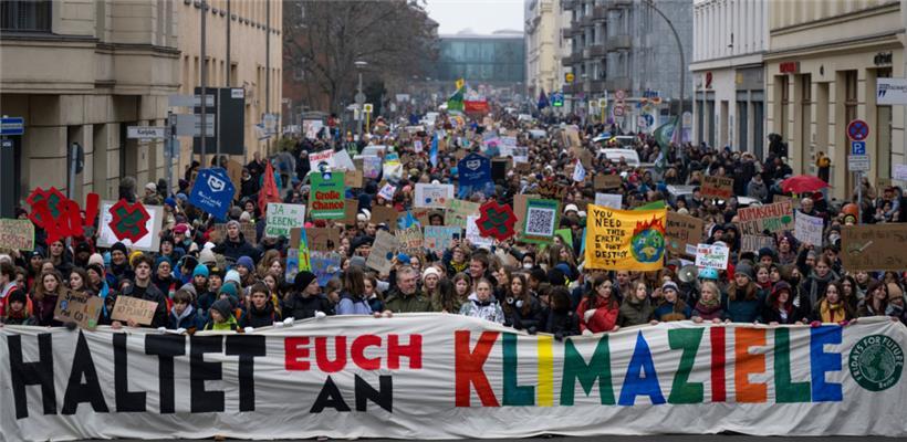 Teilnehmer der Demonstration von Fridays for Future halten ein Transparent mit der Aufschrift „Haltet euch an die Klimaziele“
