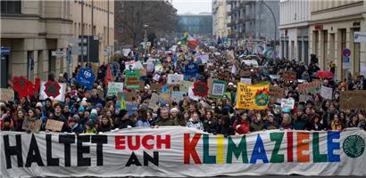 Teilnehmer der Demonstration von Fridays for Future halten ein Transparent mit der Aufschrift „Haltet euch an die Klimaziele“
