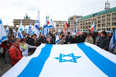 Teilnehmer einer proisraelischen Demonstration in Berlin halten gemeinsam eine große israelische Flagge. Die Demonstration „Gemeinsam gegen das Verbrechen der Hamas an Israelis und Palästinensern“ findet anlässlich des ersten Jahrestages des Überfalls der Hamas auf Israel vor dem Brandenburger Tor statt.
