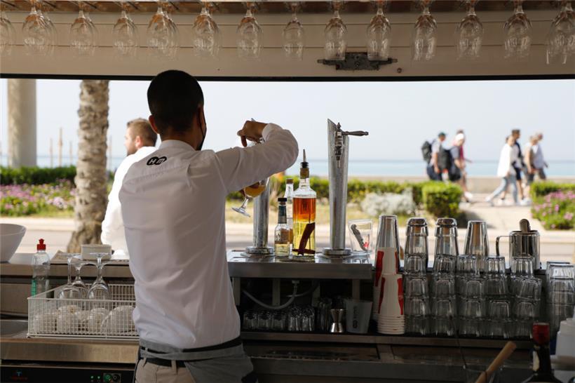 Thiago, ein Kellner, arbeitet in einer Terrassenbar am Strand von Arena auf Mallorca – ab jetzt ohne Maske und weiterhin ohne Zigarettenqualm
