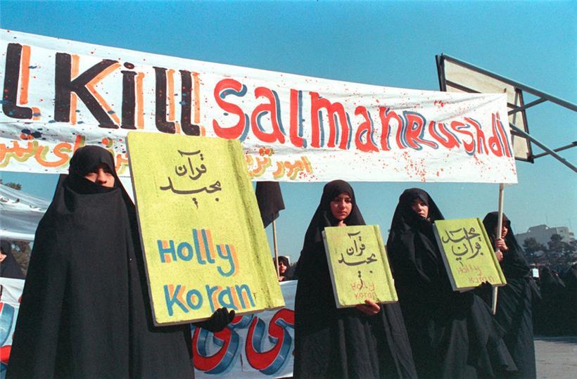 „Tötet Salman Rushdie“: Iranische Frauen halten 1989 in Teheran ein Plakat hoch
