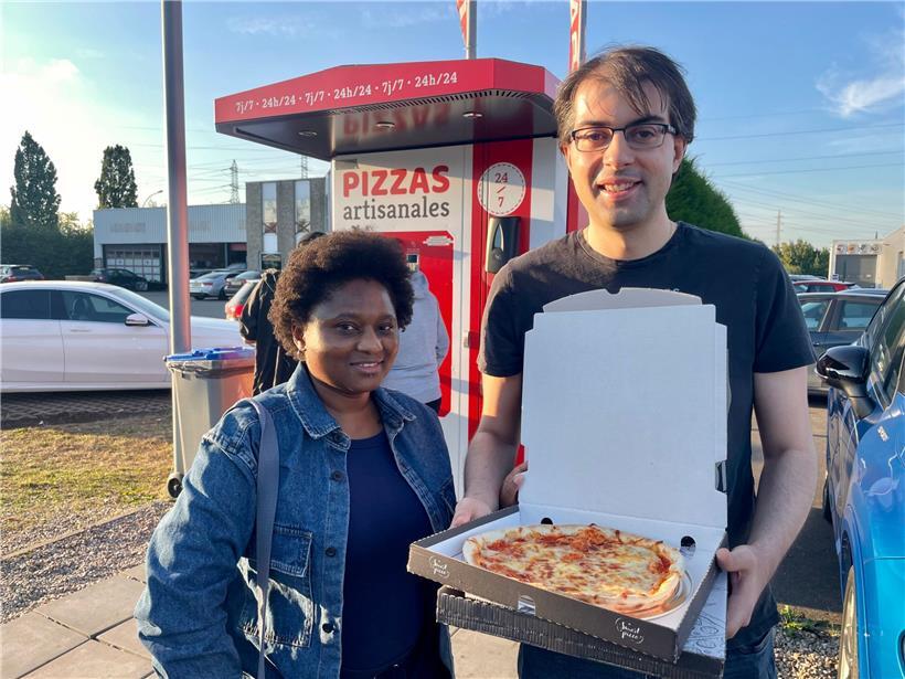 Tomupeishe Maphosa (l.) und Alfredo Rial zieht es aus Neugier zum Pizza-Automaten
