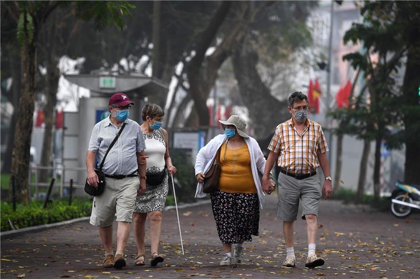 Touristen mit Mundschutz in Vietnam: Richard Hatchett will Fehler der Vergangenheit vermeiden und einen neuen Impfstoff allen zugänglich machen – Reichen und Armen
