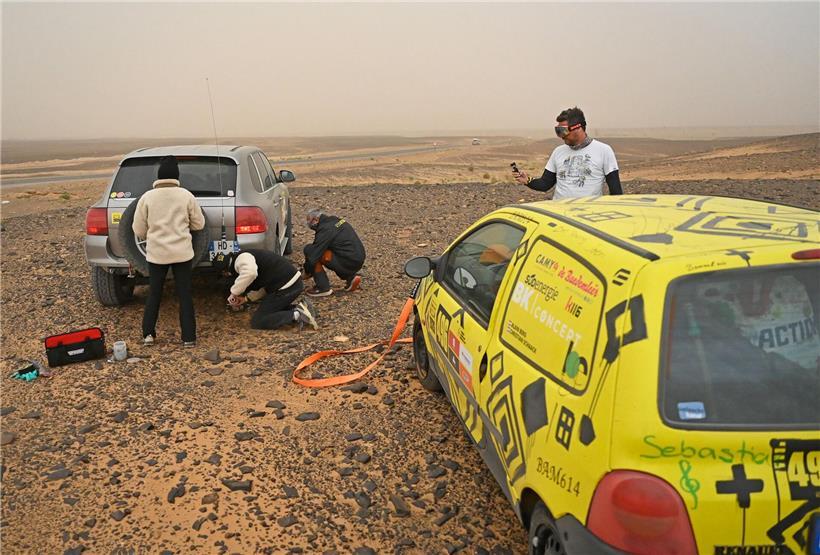 Porsche und Twingo treffen sich in der weiten marokkanischen Wüstenlandschaft bei klarem Himmel
