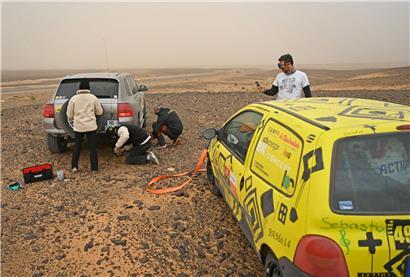 Porsche und Twingo treffen sich in der weiten marokkanischen Wüstenlandschaft bei klarem Himmel