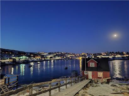 Trügerische Idylle in Aasiaat, Grönland mit bunten Häusern und ruhigem arktischem Fjord im autonomen Gebiet Dänemarks