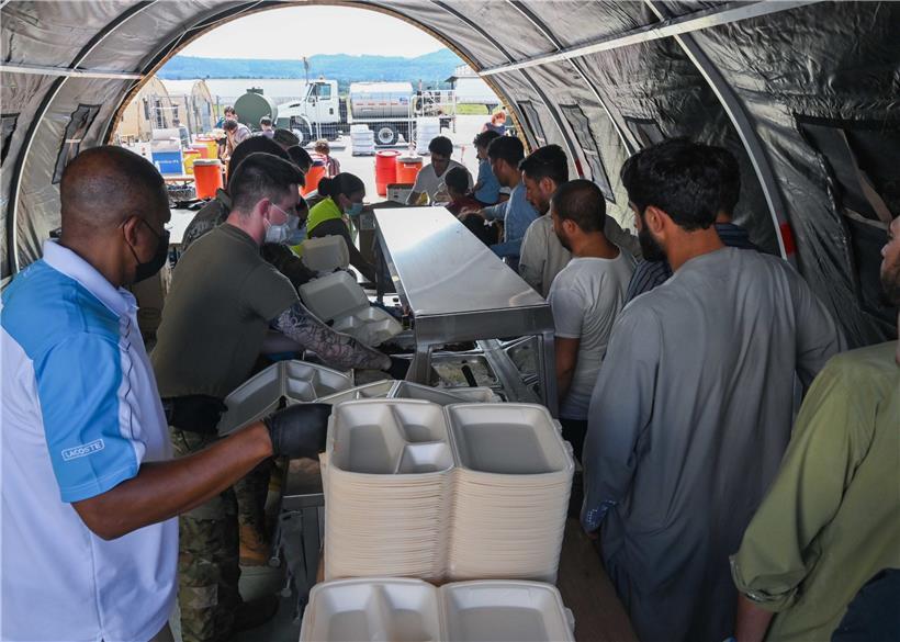 „U.S. Air Force“-Piloten bereiten Mahlzeiten für afghanische Flüchtlinge vor, die aus Kabul evakuiert wurden, nach ihrer Ankunft auf der Air-Base Ramstein

