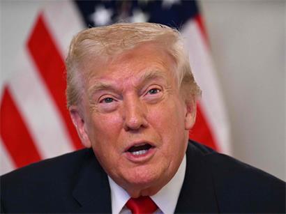 US-Präsident Donald Trump in formellem Anzug bei einer öffentlichen Rede vor amerikanischer Flagge