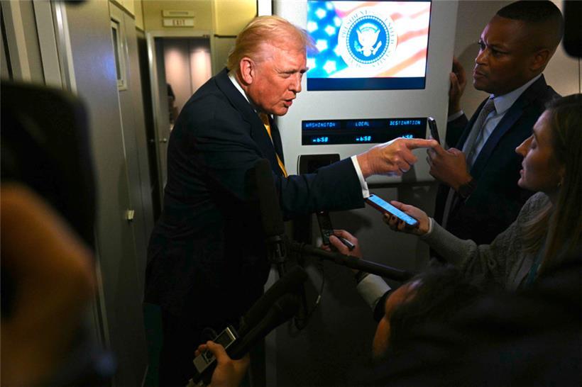 US-Präsident Donald Trump spricht an Bord der Air Force One mit Reportern
