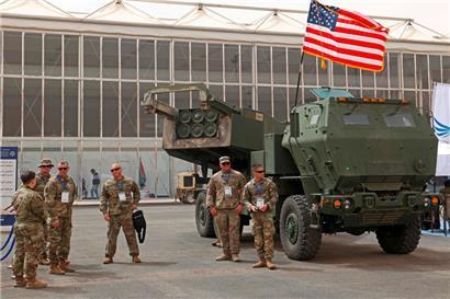 US-Soldaten stehen neben einem M142 High Mobility Artillery Rocket System (HIMARS) das nun von der ukrainischen Armee gegen die russischen Invasionstruppen eingesetzt wird
