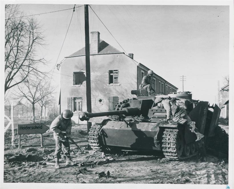 US-amerikanische Soldaten untersuchen einen von ihnen abgeschossenen deutschen Panzer, Heiderscheid, 26. Dezember 1944
