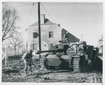 US-amerikanische Soldaten untersuchen einen von ihnen abgeschossenen deutschen Panzer, Heiderscheid, 26. Dezember 1944

