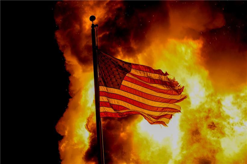 USA, Kenosha: Eine US-amerikanische Nationalflagge weht über einem Gebäude der Strafvollzugsanstalt, das während der Proteste in Brand stand. 
