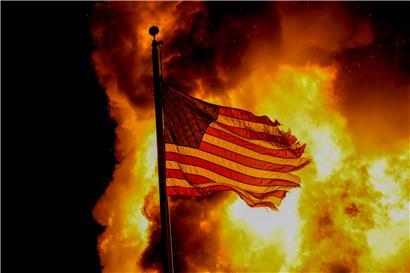 USA, Kenosha: Eine US-amerikanische Nationalflagge weht über einem Gebäude der Strafvollzugsanstalt, das während der Proteste in Brand stand. 
