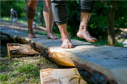 Über 550 Meter lang geht der Rundweg im Park: Die Spaziergänger wagen sich dabei über Kieselsteine oder auch Baumrinden. 
