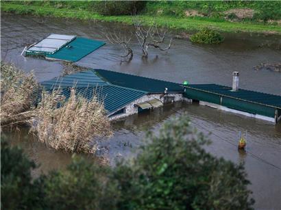 Überschwemmtes Wohnhaus in Coimbra, Portugal nach starkem Regen mit überfluteter Straße und hohem Wasserstand