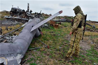 Ukraine, Schlangeninsel: Ein ukrainischer Soldat betrachtet ein beschädigtes russisches Militärflugzeug
