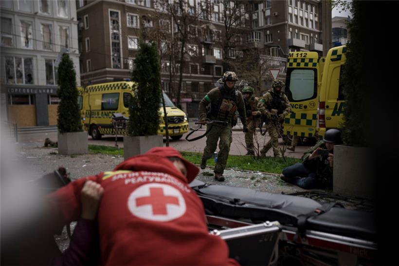 Ukrainische Soldaten gehen während eines russischen Angriffs in der Innenstadt von Charkiw in Deckung, als am Sonntag Explosionen zu hören sind
