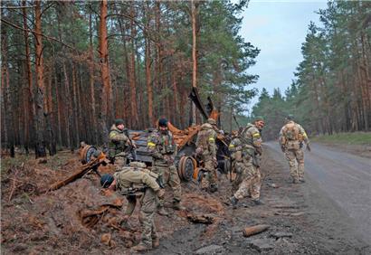Ukrainische Soldaten inspizieren ein zerstörtes russisches Panzerfahrzeug im Osten der Ukraine
