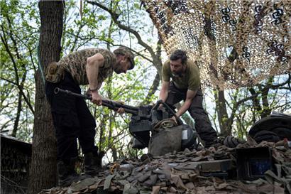 Ukrainische Soldaten installieren während Reparaturarbeiten ein Maschinengewehr auf einem Panzer nach Kämpfen gegen russische Truppen in der Region Donezk
