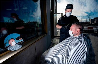 Um auf Nummer sicher zu gehen: Friseur Abed Khankan schneidet seinen Kunden in Malmö die Haare draußen
