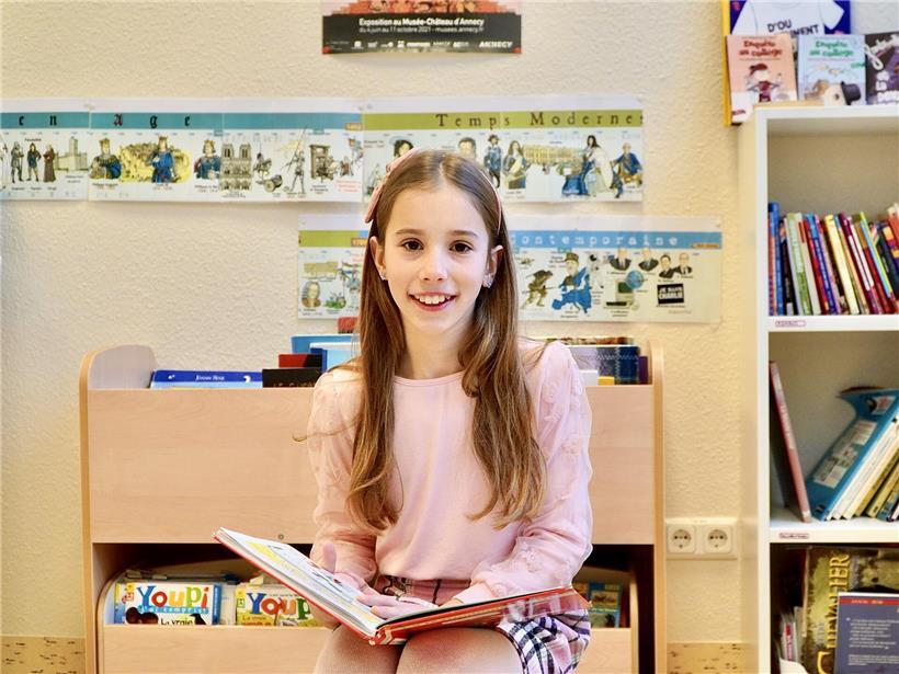 Eline glücklich umgeben von spannenden Geschichten in gemütlicher Leseecke mit Büchern und warmem Licht