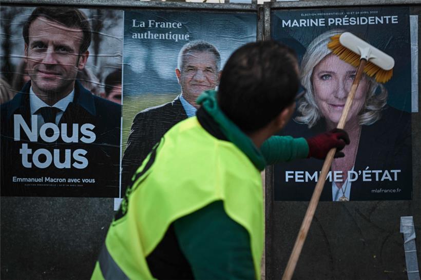 Un employé d’une société d’affichage placarde les affiches de la campagne officielle des candidats à l’élection présidentielle
