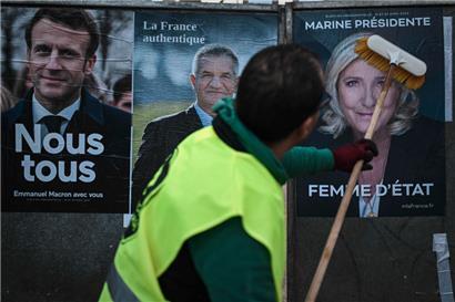 Un employé d’une société d’affichage placarde les affiches de la campagne officielle des candidats à l’élection présidentielle
